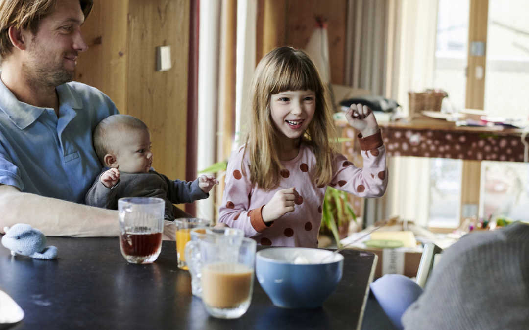 Fröhliche Familie sitzt am Tisch